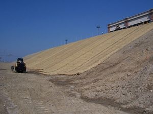 This picture shows an erosion control blankets being installed along a steep slope