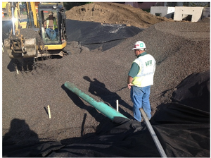 This picture shows a Infiltration media being placed in infiltration area with tracked backhoe