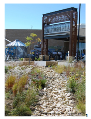 This photo shows a Rain garden at main entrance into mall showing cistern - interpretive signage and rain garden