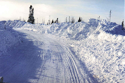 Photo showing Snow plowed and piled on road