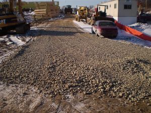 This photo shows Add additional aggregate regularly to maintain a vehicle-tracking pad.
